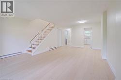 Light wood-finish flooring throughout,  flush-mount ceiling light fixtures, clean welcoming space. - 