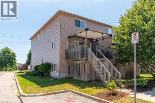 Second-story deck with wood railing and stairs - 50 Howe Drive Unit# 19B, Kitchener, ON 