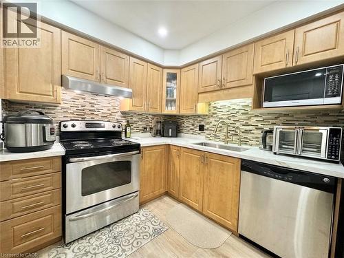 Wood-finish cabinetry paired with white countertops - 1335 Countrystone Drive, Kitchener, ON 