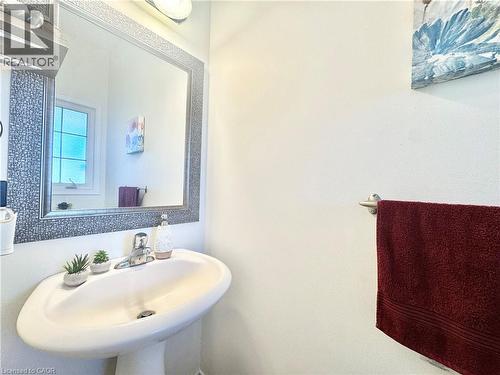 Pedestal sink with chrome faucet, framed mirror, and wall-mounted towel bar - 1335 Countrystone Drive, Kitchener, ON 