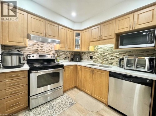 Wood-finish cabinetry paired with white countertops - 1335 Countrystone Drive, Kitchener, ON 