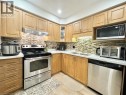 Wood-finish cabinetry paired with white countertops - 1335 Countrystone Drive, Kitchener, ON 