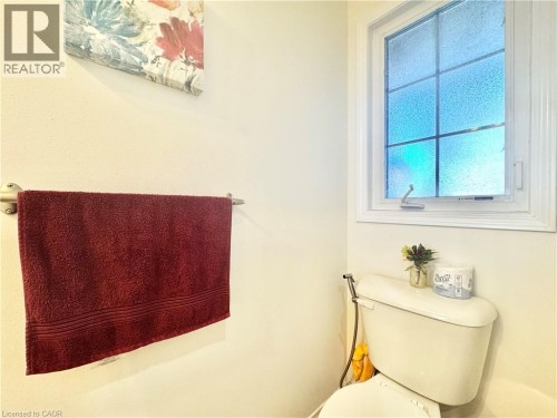 Window with privacy glass and white trim, toilet with bidet attachment, and wall-mounted towel bar - 1335 Countrystone Drive, Kitchener, ON 