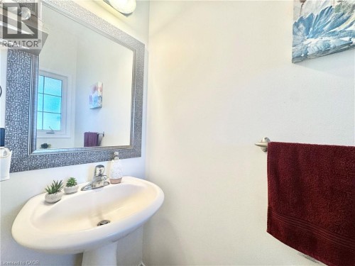 Pedestal sink with chrome faucet, framed mirror, and wall-mounted towel bar - 1335 Countrystone Drive, Kitchener, ON 