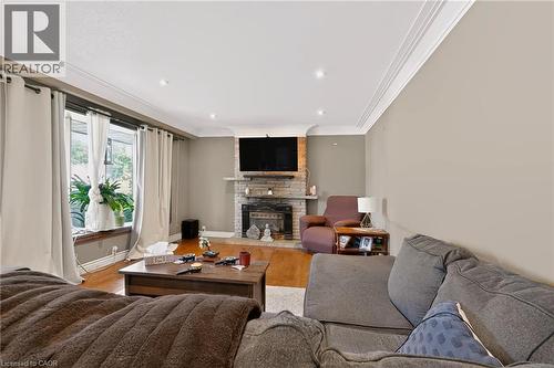 Hardwood flooring, recessed lighting, crown molding, stone-clad fireplace, and large windows - 1046 Shepherds Drive, Burlington, ON 