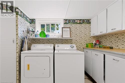 Laundry area with built-in cabinetry, upper storage cabinets, and a window - 1046 Shepherds Drive, Burlington, ON 