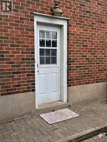 Brick exterior with a white paneled door featuring a window insert - 1046 Shepherds Drive, Burlington, ON 