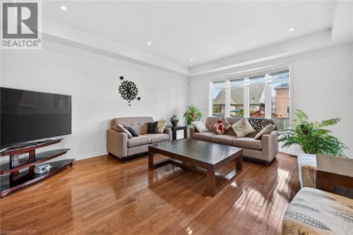 Living room with a tray ceiling, hardwood / wood-style floors, and recessed lighting - 97 Sirente Drive, Hamilton, ON 