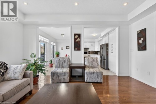 Living area with light wood-type flooring, recessed lighting, and a raised ceiling - 97 Sirente Drive, Hamilton, ON 