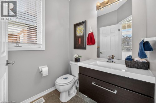 Half bath featuring vanity and dark tile patterned flooring - 97 Sirente Drive, Hamilton, ON 