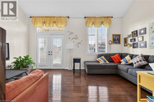 Living room featuring dark wood-style floors, french doors, and lofted ceiling - 97 Sirente Drive, Hamilton, ON 