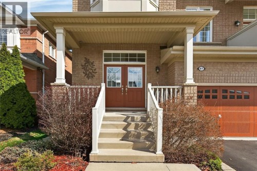 Doorway to property with a porch, brick siding, and a chimney - 97 Sirente Drive, Hamilton, ON 