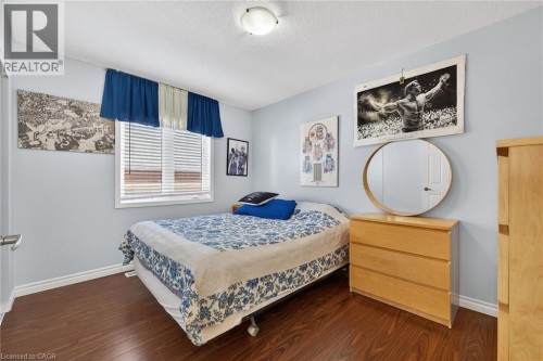 Bedroom featuring dark wood-type flooring and a textured ceiling - 97 Sirente Drive, Hamilton, ON 
