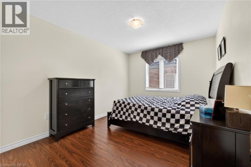 Bedroom with dark wood-type flooring and a textured ceiling - 97 Sirente Drive, Hamilton, ON 