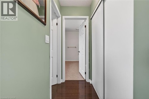 Corridor featuring dark wood-style floors and a textured ceiling - 97 Sirente Drive, Hamilton, ON 