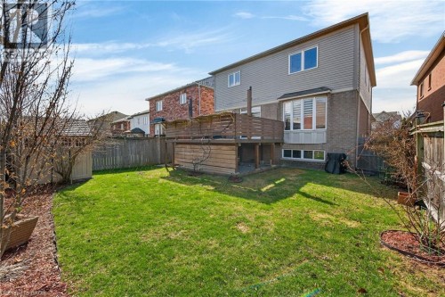 Back of house featuring a fenced backyard, brick siding, and a wooden deck - 97 Sirente Drive, Hamilton, ON 