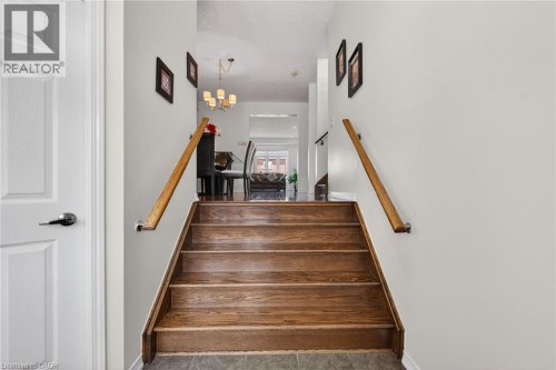 Staircase featuring hanging lights and baseboards - 97 Sirente Drive, Hamilton, ON 