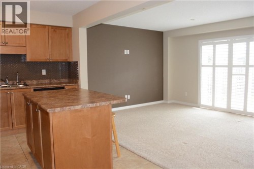 Kitchen with wood cabinetry, a central island with a countertop, and a diamond-patterned backsplash - 507 Beaumont Crescent, Kitchener, ON 