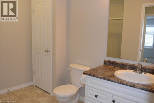 Bathroom featuring a single vanity with a laminate countertop, integrated sink, and chrome faucet - 507 Beaumont Crescent, Kitchener, ON 