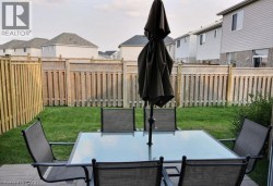Fenced backyard with mature lawn and wood-finish privacy fencing - 