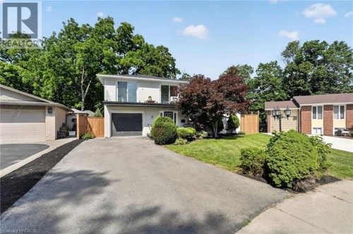 Contemporary-style residence featuring a white facade and a dark gray garage door - 9 Leslie Drive, Hamilton, ON 