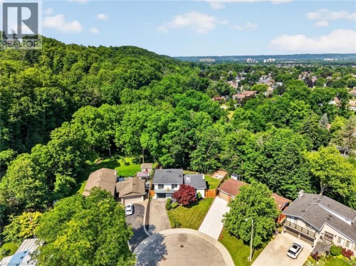 Aerial perspective showcasing a residential cul-de-sac with surrounding mature trees and distant urban landscape - 9 Leslie Drive, Hamilton, ON 