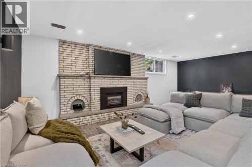 Living area featuring a brick-clad fireplace with a hearth and a built-in firebox - 9 Leslie Drive, Hamilton, ON 