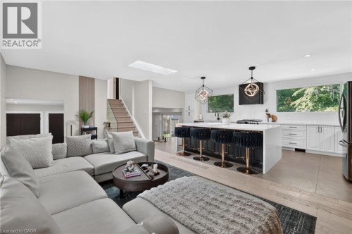 Open-concept living area with light wood-finish flooring - 9 Leslie Drive, Hamilton, ON 
