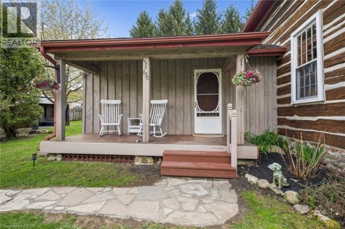 Covered front porch with wood plank siding, a decorative screen door, and a stone walkway - 630 Robert Ferrie Drive, Kitchener, ON 