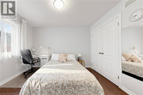 Wood-finish flooring, a double-door closet, and a built-in mirrored wardrobe - 173 Raymond Road, Ancaster, ON 