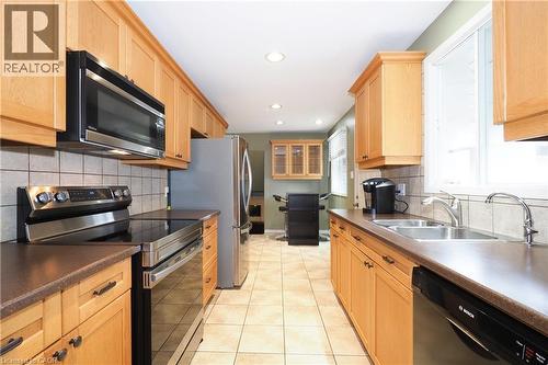 Kitchen featuring light wood cabinetry, stainless steel appliances, tiled backsplash, and recessed lighting - 219 Foxhunt Road, Waterloo, ON 