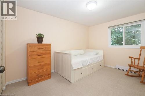 Neutral wall color, carpeted flooring, large window, flush mount ceiling light, baseboard heating - 219 Foxhunt Road, Waterloo, ON 