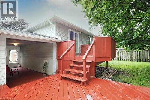 Expansive outdoor wooden deck with red finish, featuring steps and railing - 219 Foxhunt Road, Waterloo, ON 