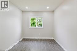 Recessed ceiling lighting, a white framed window, and wood-finish flooring - 
