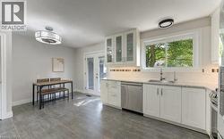 Kitchen featuring white cabinetry, stainless steel appliances, granite-style countertops, and a tile backsplash - 