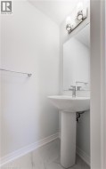 Pedestal sink with chrome fixtures and wall-mounted lighting - 