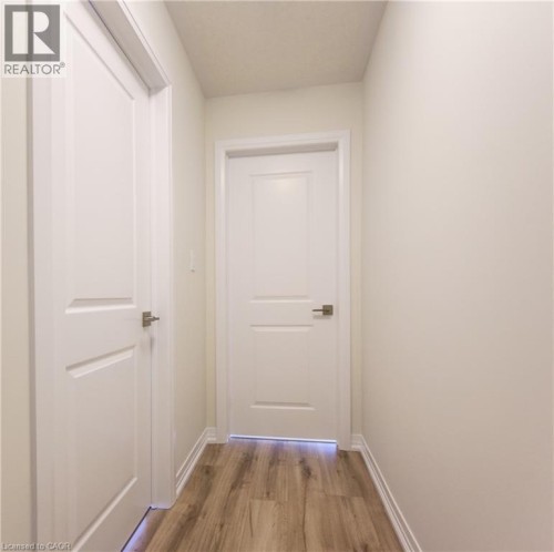 Smooth wood-finish flooring, white panel doors, and neutral wall tones - 25 Urbane Boulevard, Kitchener, ON 