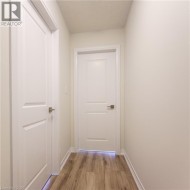 Smooth wood-finish flooring, white panel doors, and neutral wall tones - 
