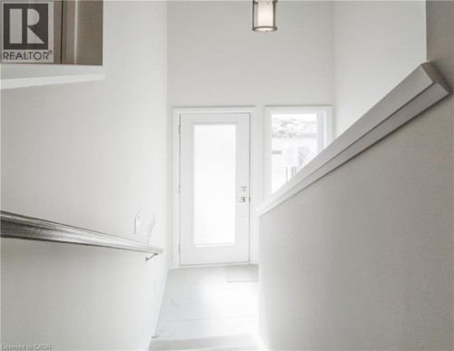 Frosted glass door with sidelight, overhead lighting fixture, and a modern handrail - 25 Urbane Boulevard, Kitchener, ON 