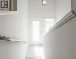 Frosted glass door with sidelight, overhead lighting fixture, and a modern handrail - 