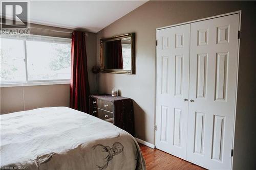 Vaulted ceiling with a large window, panel bi-fold closet doors, and wood-finish flooring - 1 Vera Court, Hamilton, ON 