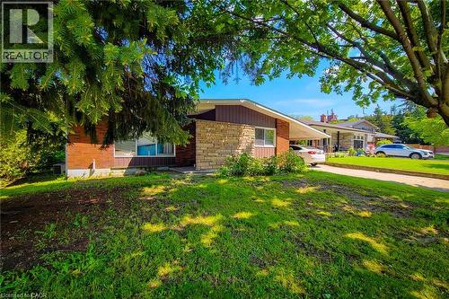 Brick exterior with stone accents, a single-pane window, and an attached carport - 1 Vera Court, Hamilton, ON 
