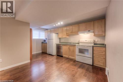 Wood-finish flooring, light wood cabinetry, white kitchen appliances, and track lighting - 8 Melran Drive Unit# 2, Cambridge, ON 