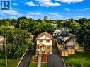Two-story property featuring a stone and siding facade, covered front entry porch, and dual paved driveways - 67 Kinzie Avenue, Kitchener, ON 
