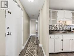 Kitchen featuring white cabinetry, dark countertops, and a mosaic tile backsplash - 