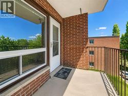 Private balcony with textured flooring, brick exterior, and metal railings - 
