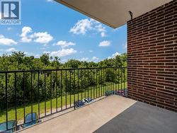 Concrete balcony with black metal railing and brick exterior wall - 