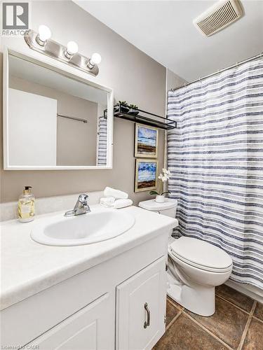 White vanity with an integrated sink, brushed nickel faucet, and a wall-mounted mirror - 4 Avalon Place Unit# 303, Kitchener, ON 