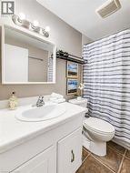 White vanity with an integrated sink, brushed nickel faucet, and a wall-mounted mirror - 