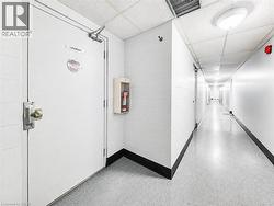 Extended hallway with durable flooring, acoustical tile ceiling, and overhead lighting - 
